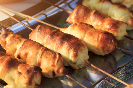 Dough with sausage inside baked on grillの写真素材
