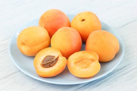 Tasty apricots on blue plateの写真素材