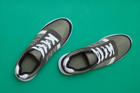 Sport shoes sneakers on green background, top view layoutの写真素材