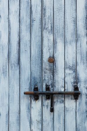 Village house door lock bolt. Closed wooden door with metallic simple bar bolt.の写真素材
