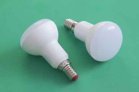 LED lamps on green background. Low power ecology friendly bulb lamps for household usage. Point lighting socket.の写真素材