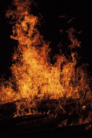 Big hot flames of campfire on black background. Night fire burning.の写真素材