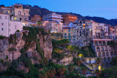 Tropea, Italy - September 9, 2019: Evening view on old ancient town on mountain rock. Buildings and street lights with dusk sunlight color.のeditorial素材