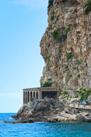 Scilla, Italy - September 7, 2019: View on car road tunnel on side of rock mountain of the Ruffo Castle. Sea and town road with concrete tunnel.のeditorial素材