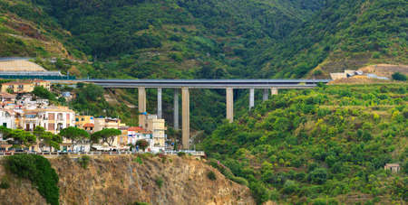 Scilla, Italy - September 8, 2019: Landscape with Scilla town and bridge highway on green mountain hillsのeditorial素材