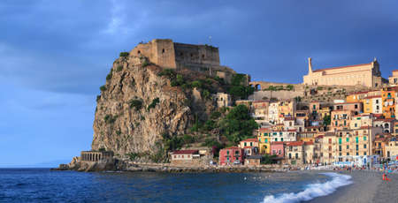 Scilla, Italy - September 7, 2019: The Ruffo Castle on mountain rock. View from central beach of town with sea waves and sunlight. Panorama of ancient castle and town on hills.のeditorial素材