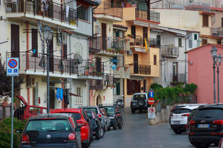 Scilla, Italy - September 7, 2019:  Central street of town with car parking and traditional buildings. Long  asphalt road street view.のeditorial素材