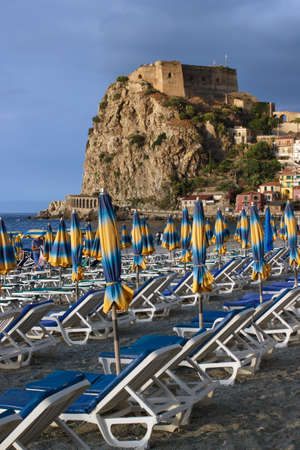 Scilla, Italy - September 7, 2019: View of beach lounge deck and ancient Ruffo Castle. Medieval fortress view from beach coastline.のeditorial素材