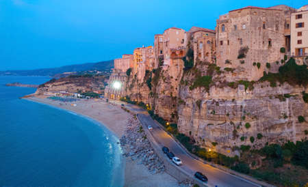Tropea, Italy - September 8, 2019: Central sea beach of Tropea in evening dusk lighting with street illumination and people near the sea water.のeditorial素材