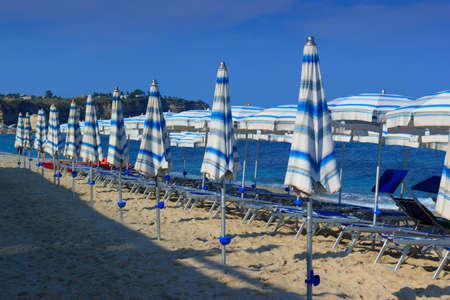 Morning sea beach with deck chairs and umbrellas in sandの写真素材