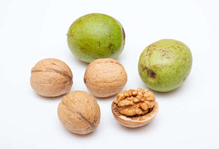 Natural walnuts on white background. Unpeeled and cracked with kernel.の写真素材