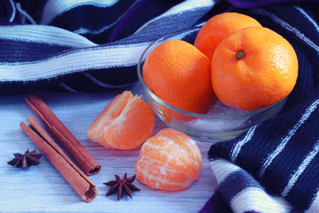 Natural tangerines mandarines with aromatic spices and warm knitted scarf closeup