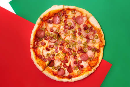 Italian pizza from top with red, green and white color backgroundの写真素材