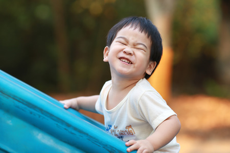 A happy young boy playing on playgroundの写真素材