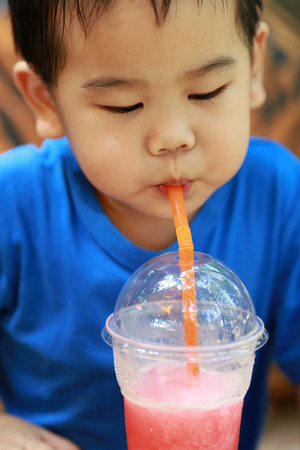 Young boy is drinking juiceの写真素材