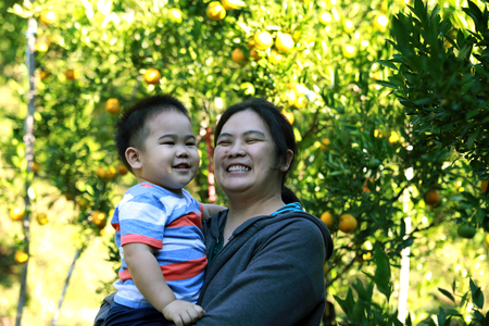 smiling young boy and his mother in the orange farmの写真素材