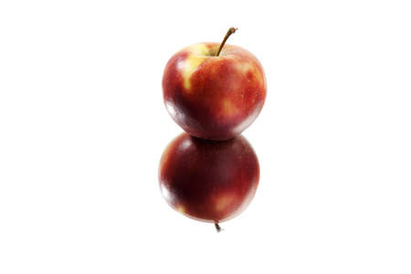 Red apple on a mirror against a white backgroundの写真素材