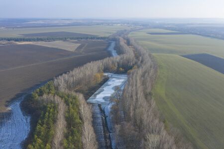 Landing in the middle of a icy river in the forest with yellow trees. Beautiful view from above....
