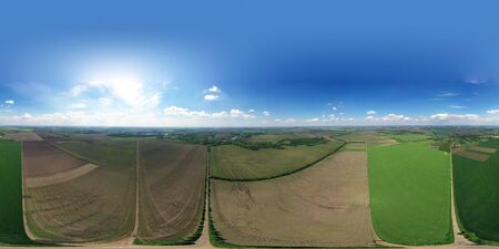 Roads in the field and meadows. Beautiful singing expanses of Ukrainian land. Black soil and lots of green trees. Spring aerial shot from a drone. Top view of the road with a crossroads and dense green forests. Beautiful bright landscape photography with drone on a spring dayの写真素材