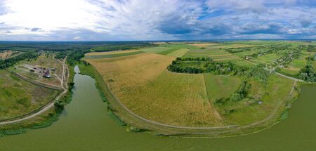 360-degree aerial view from a drone of a large river and green meadows in the countryside