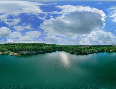 Drone Aerial panoramic view over the water of a large lake with stone shores. Colorful sky panorama...