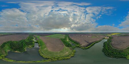 Drone Aerial 360 Degree panoramic view over the water of a large lake with stone shores. Colorful sky panorama with white clouds and a blue sky. Incredibly beautiful landscapeの写真素材