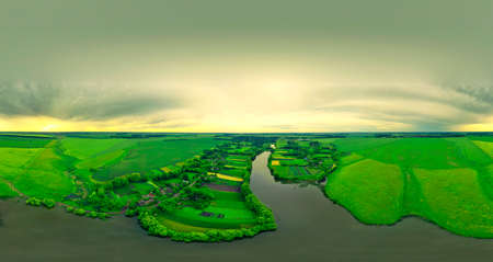 Colorful panorama from a copter over a wide river, fields, meadows. Beautiful panorama at sunset in summer. Panoramic aerial view of the field, forest and river. Colorful panorama at sunset in summer.の写真素材