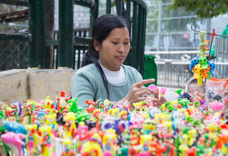 HANOI, VIETNAM - JAN 1, 2016: Female Vietnamese civilian artist (handicrafts man) making traditional toys (called To He) for children from special material of grain and colorful flour.のeditorial素材