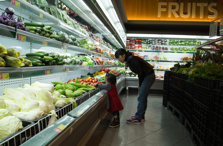 Hanoi, Vietnam - Jan 1, 2015: Asian people go shopping at a supermarket and choosing fresh fruit in Hanoi capital. Retail industry as well as supermarket is growing fast in this developing country.のeditorial素材