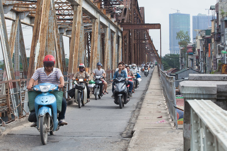 Hanoi, Vietnam - Nov 11, 2015: Vietnamese people riding motorcycles on Long Bien bridge over Hong...