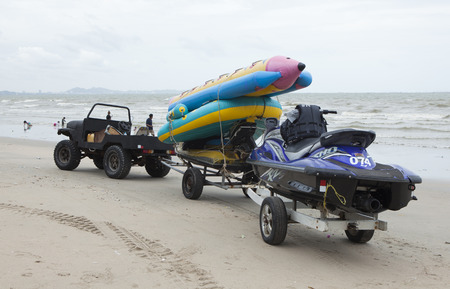 Si Racha, Thailand - Jul 18, 2015: A 4x4 car pulling a rickshaw on the beach of Si Racha. Si Racha is a town in Thailand on the east coast of the Gulf of Thailand.のeditorial素材