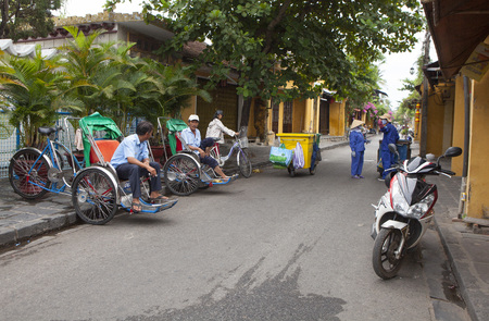 Hoi An, Vietnam - Jun 20, 2015: Cyclo drivers waiting for passenger on the side of a street in Hoi...