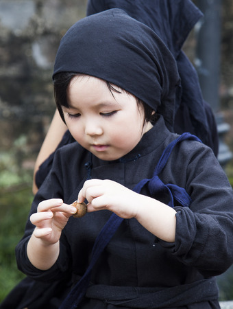 Hanoi, Vietnam - Sep 14, 2016: Vietnamese little children on traditional dresses resting while visiting Temple of Literature in Hanoi capital.のeditorial素材