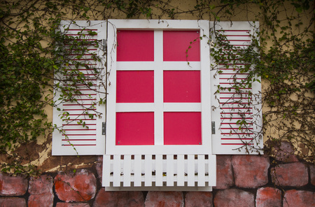 Close up of a romantic pink and white windows on brick wall backgroundの写真素材