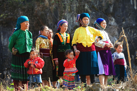 HA GIANG, VIETNAM - FEB 7, 2014: A group of unidentified Hmong women and children watching a traditional performance within a holiday called Tet under the sunlight of spring.のeditorial素材
