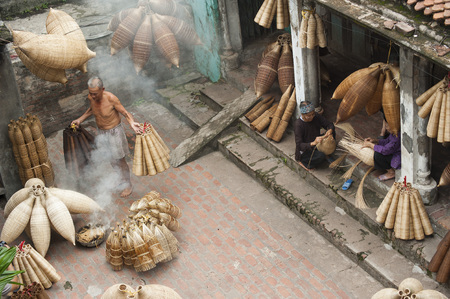 Hung Yen, Vietnam - Jul 26, 2015: Vietnamese craftsmen making bamboo handicraft products to maintain a traditional handicraft in a countryside of Vietnam.のeditorial素材