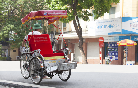 HANOI, VIETNAM - JUL 12, 2014: Life in Vietnam - cyclo driver waiting for customers in Sword lake. Cyclo is one of the most favorite vehicles for tourist when come to Vietnam's cities.のeditorial素材