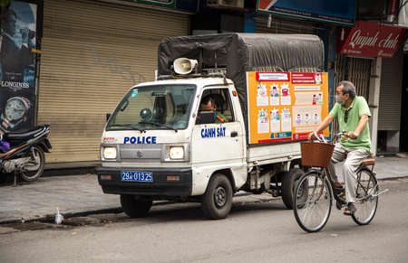Hanoi, Vietnam - Mar, 28, 2020: A police car observing people on a street of Hanoi capital in time of Corona virus prevention (Covid-19).のeditorial素材