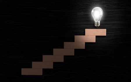 Light bulb glows in top of stairway in black texture background. success process concept.の写真素材