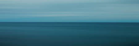 Panoramic blurred smooth blue beach background, blue sea and blue sky. panorama background with Blurred lines texture. Panorama bannerの写真素材