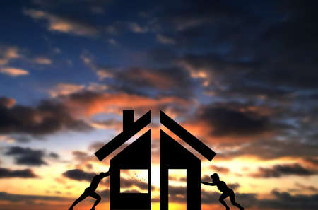 Man And Woman Connect 2 parts of A House together, Pushing Hardly the two pieces of home. Concept photo of a successful home building by wife and husbandの写真素材