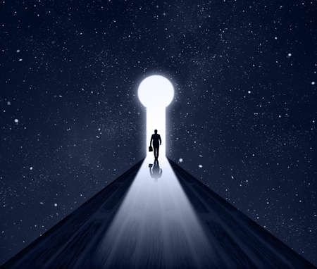 Businessman walking thought A Keyhole on Cosmos stars background with dark blue night starry sky. Man walks In Success Way. Bright Road Light and Key Hole. Business man Success Idea Concept.の写真素材