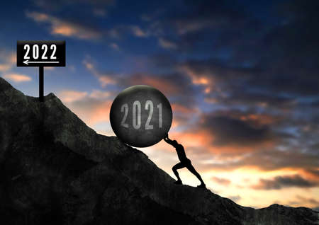 2021 2022 concept. Man pushing concrete big stone (2021) uphill To Reach 2022 Sign . Guy push up hardly the concrete. Hard Work in 2021 Success in 2022 Conceptの写真素材