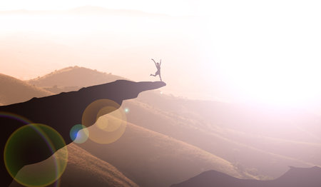 Silhouette of a man jumping over a precipice. The concept of a healthy lifestyle.の写真素材