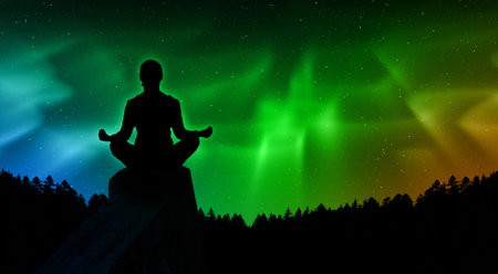 Silhouette of man meditating in lotus pose against aurora borealisの写真素材