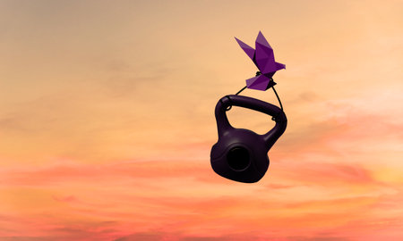Origami Bird Trying Hardly To Fly while Tied to A Heavy Weight of Kettlebell. Restriction, Freedom, Struggle and Prisoner Challenge Conceptの写真素材
