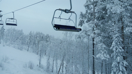 Winter forest in the mountains and ski liftの写真素材