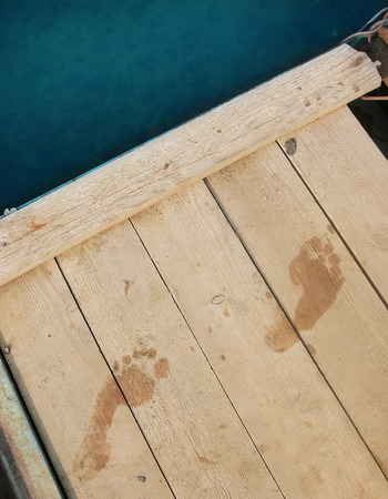 Wet footprints on the wooden pierの写真素材
