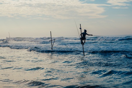 Local fisherman on stick on a beach of Indian ocean, Sri Lankaの写真素材