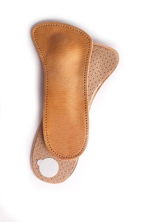 Isolated orthopedic insole on a white background. Treatment and prevention of flat feet and foot diseases. Foot care, comfort for the feet. Wear comfortable shoes. Medical insoles. Flat Feet Correction.の写真素材